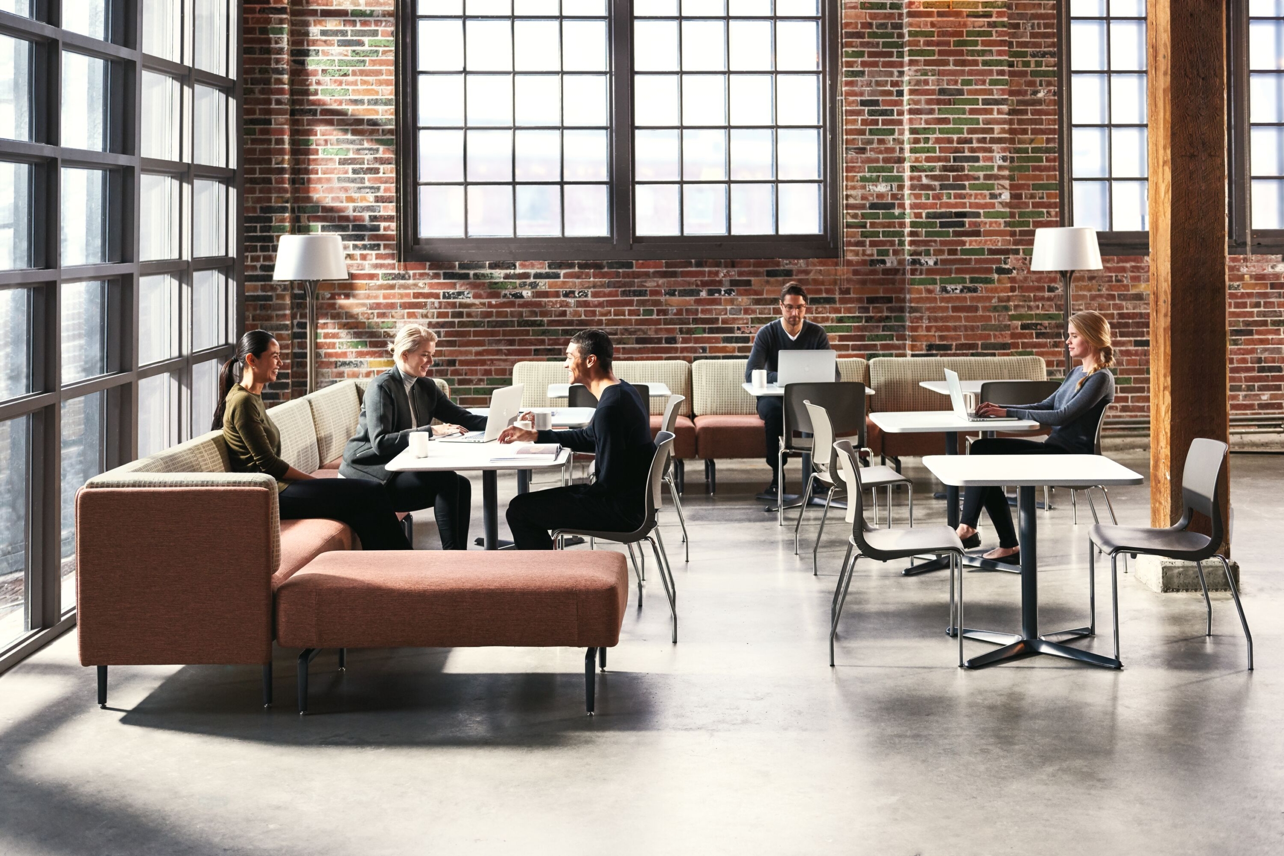 A collaborative workspace filled with people, featuring Teknion's Banqs Cafe Collection