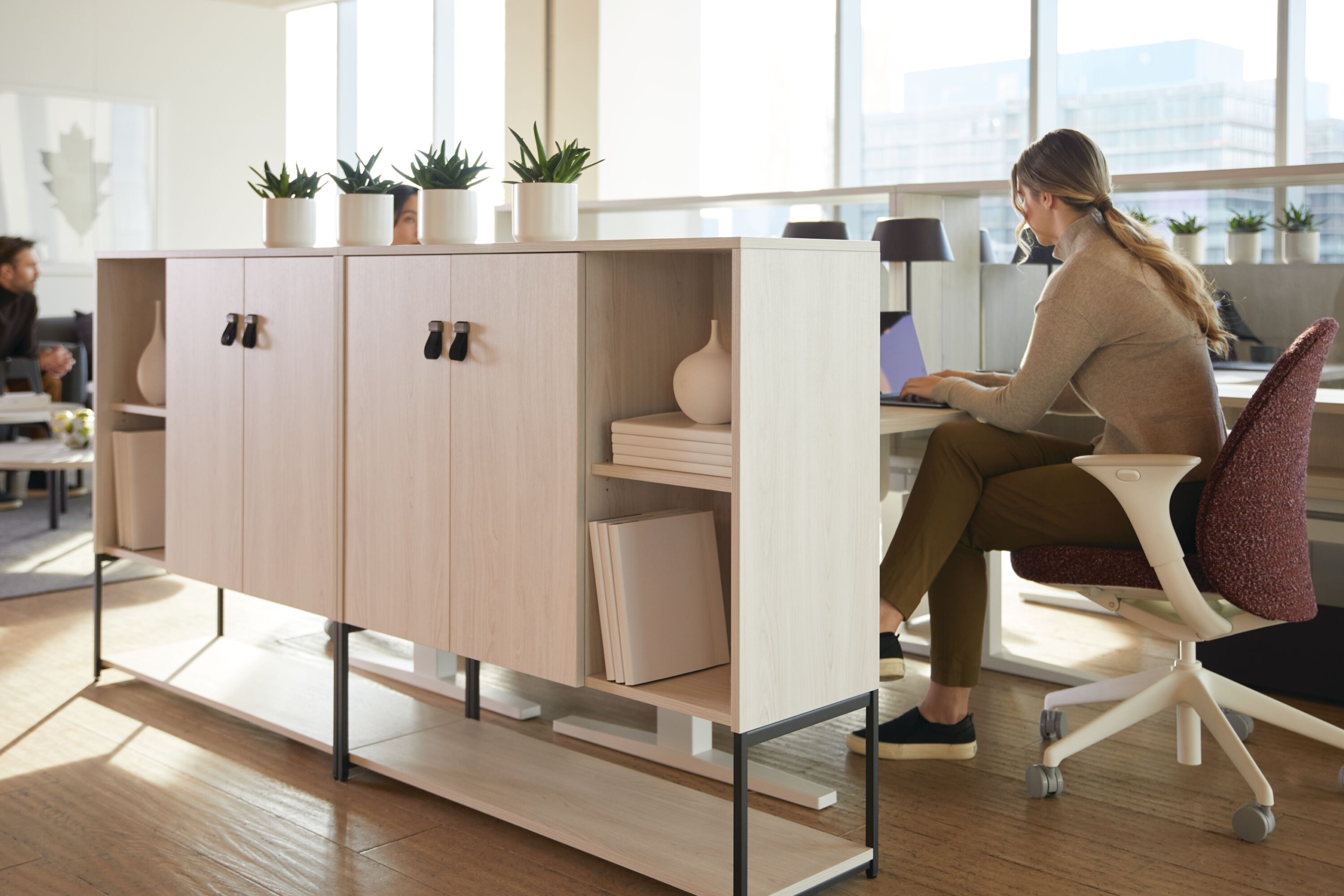 A woman working at her workstation featuring Teknion's Byward storage
