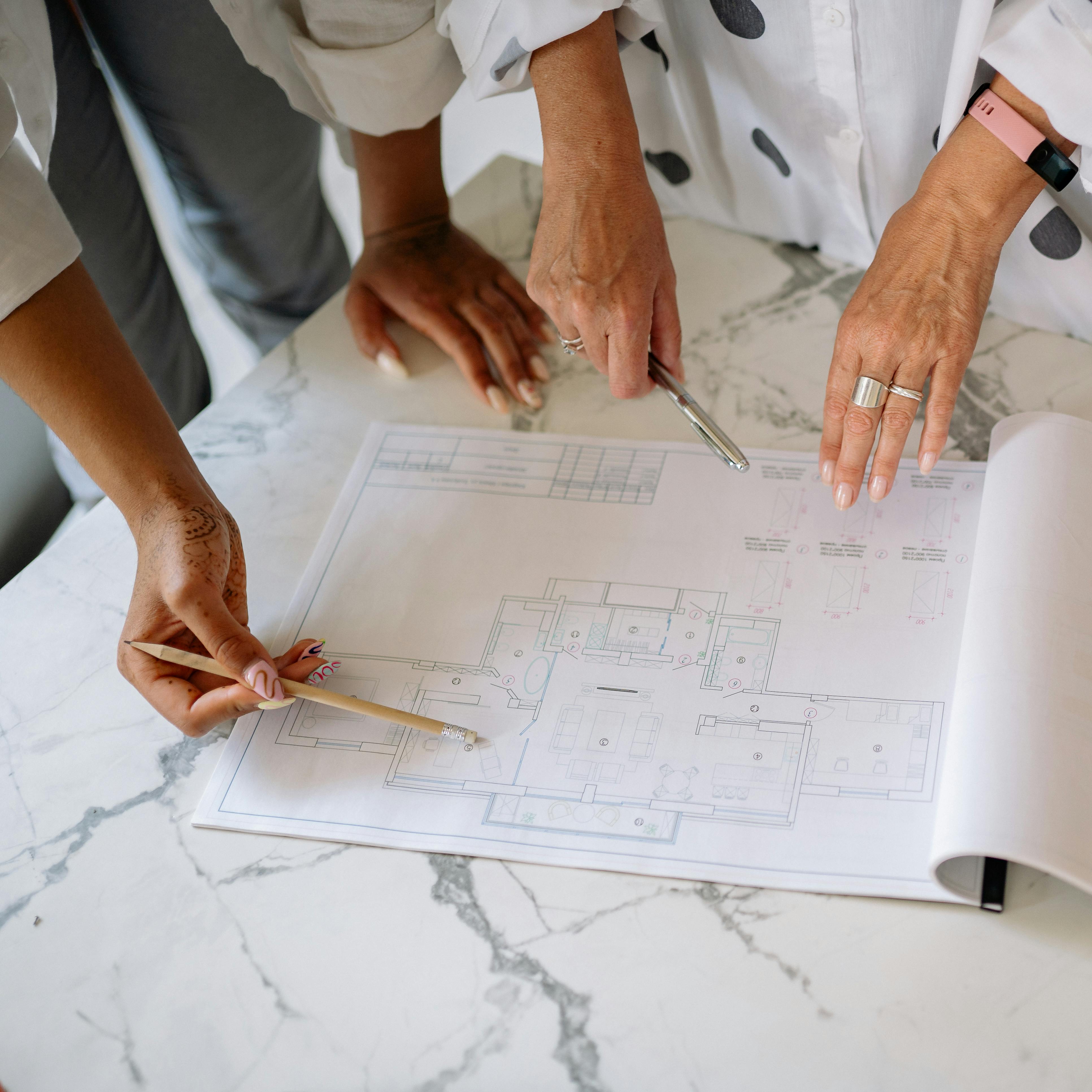 Two women looking at floor plans for a project